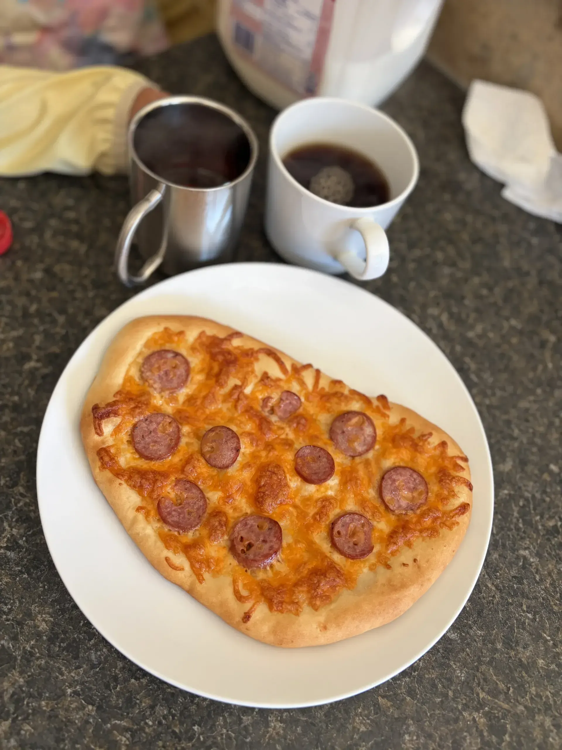 Homemade flatbread pizza with melted cheese and sausage on a plate