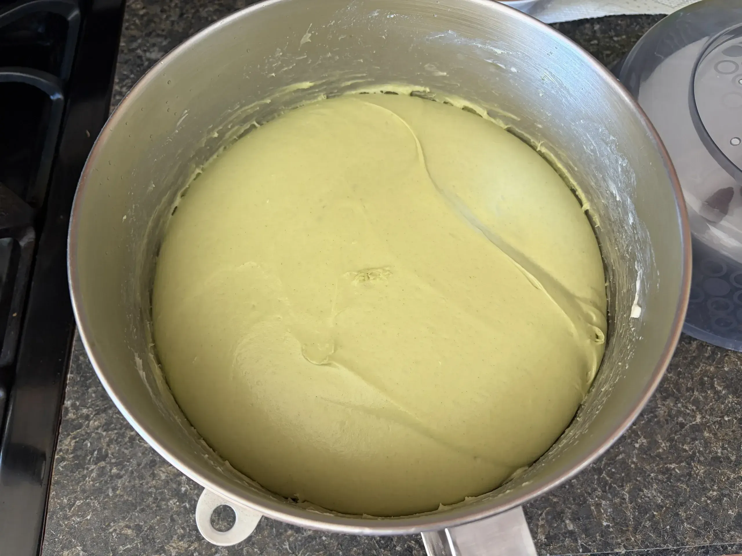 Green spinach dough risen in mixer bowl