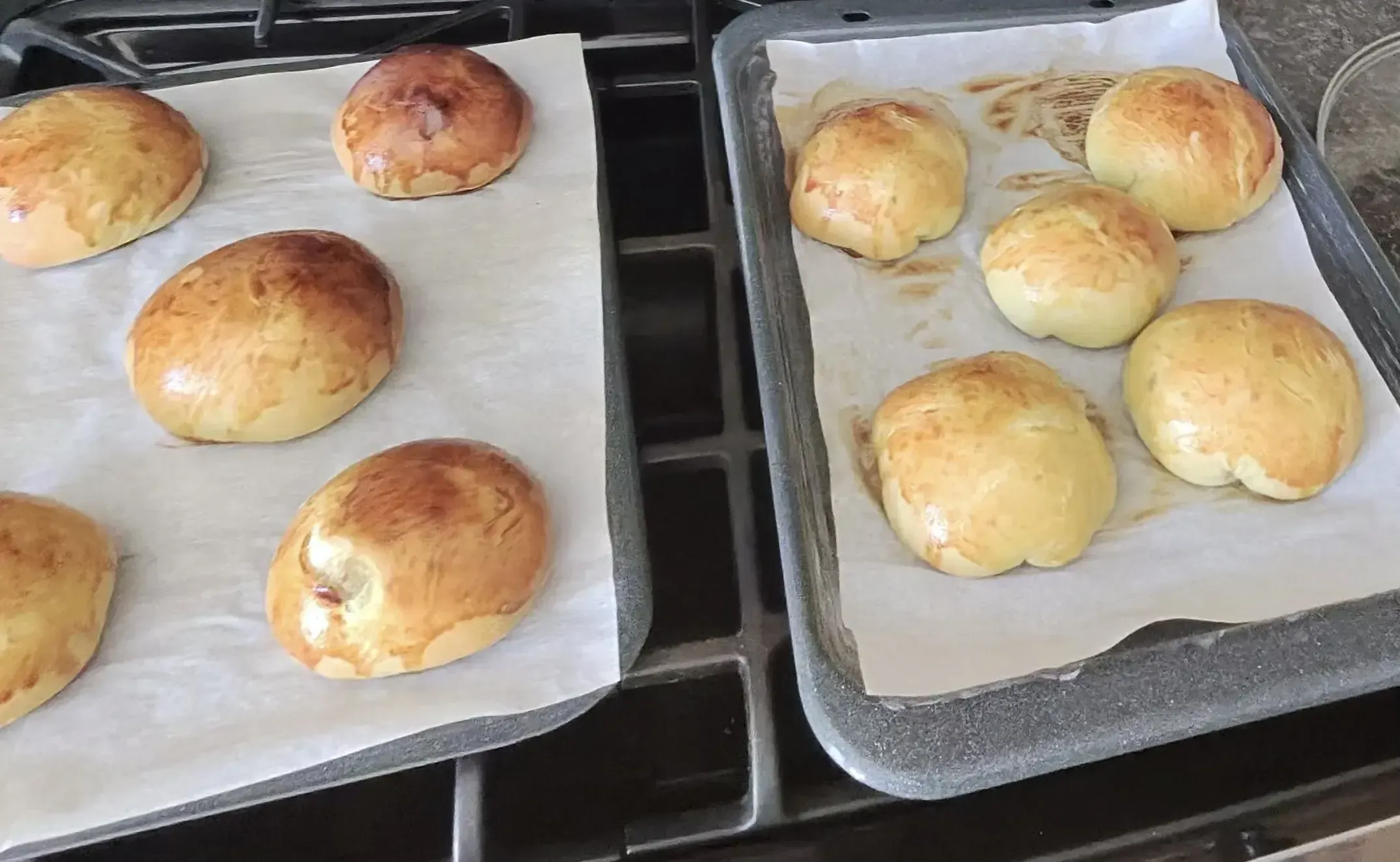 Golden brown baked buns on baking sheets